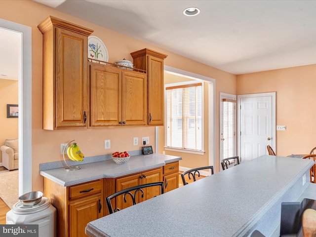 kitchen featuring light countertops, brown cabinetry, and recessed lighting