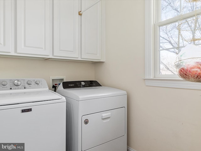 laundry room featuring cabinet space, separate washer and dryer, and a wealth of natural light