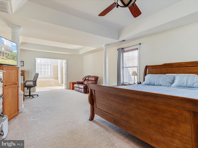 bedroom featuring visible vents, light carpet, a raised ceiling, and decorative columns