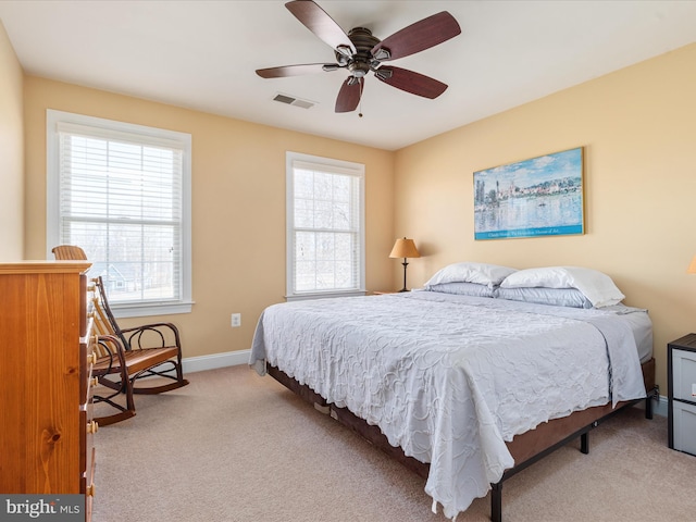 bedroom with light carpet, baseboards, multiple windows, and visible vents