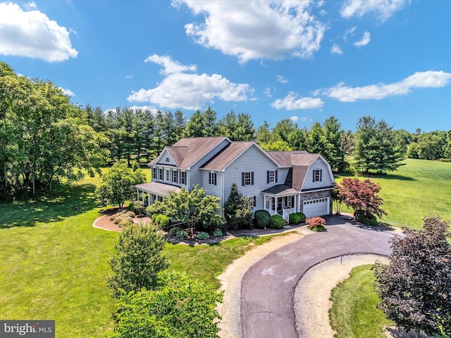 view of front of house featuring driveway, a garage, a front lawn, and a gambrel roof