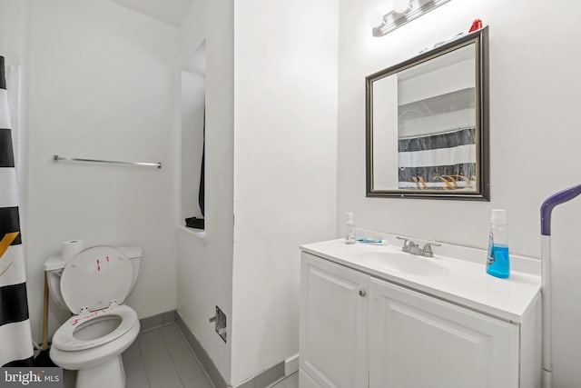 bathroom featuring toilet, tile patterned flooring, vanity, and baseboards