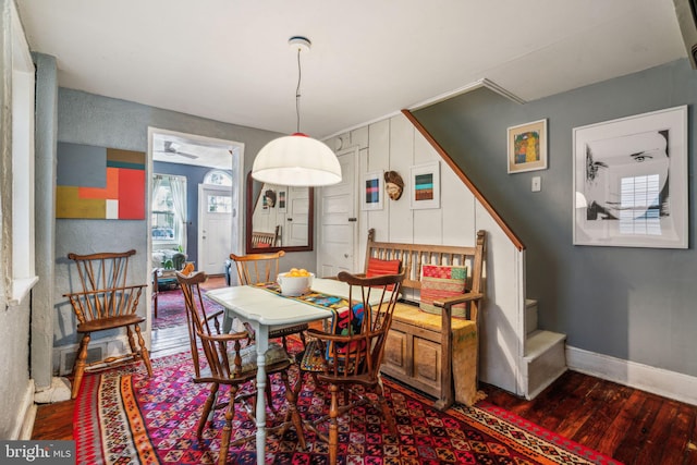 dining space featuring stairway, wood finished floors, and baseboards