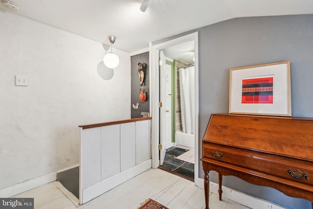 interior space featuring lofted ceiling, wood finished floors, and baseboards