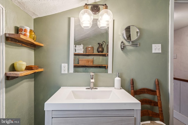 bathroom with lofted ceiling, vanity, and a textured ceiling