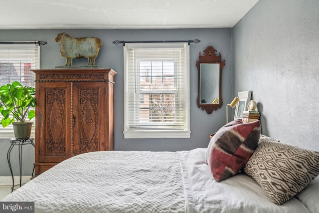 bedroom with multiple windows and a textured wall