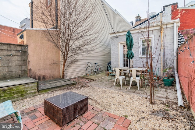 view of patio featuring outdoor dining space and fence