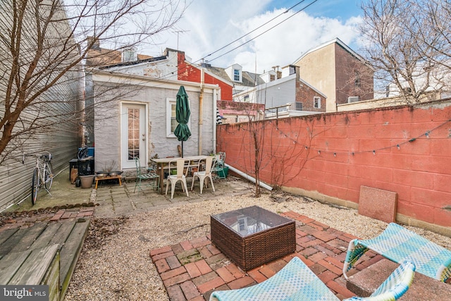 view of patio featuring an outdoor structure and a fenced backyard