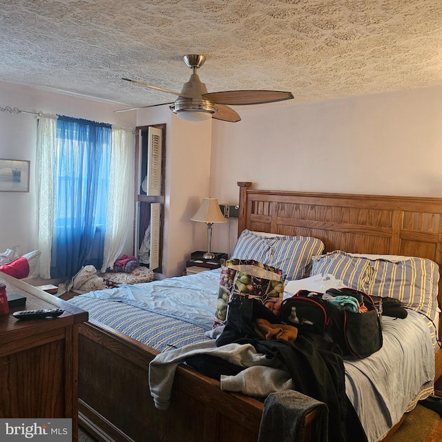 bedroom with a ceiling fan and a textured ceiling