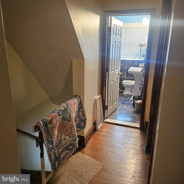 hallway featuring tile walls and hardwood / wood-style flooring