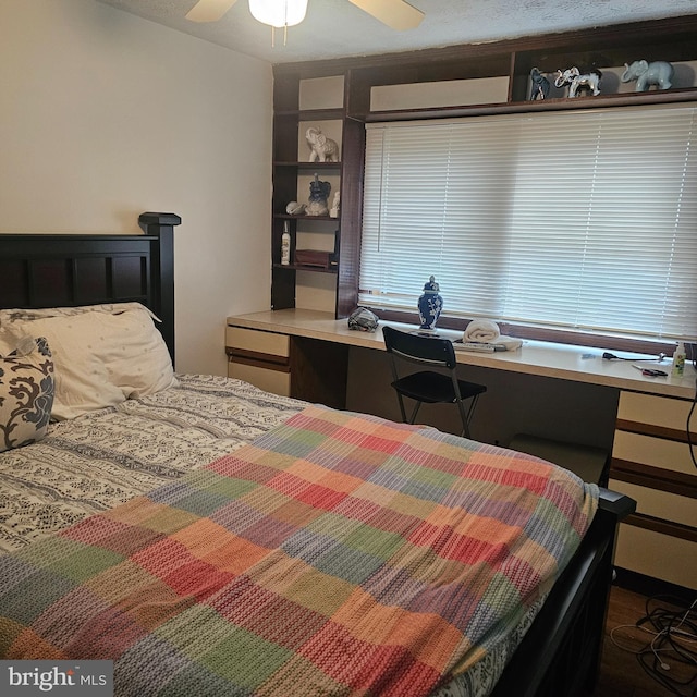 bedroom with a ceiling fan and built in desk