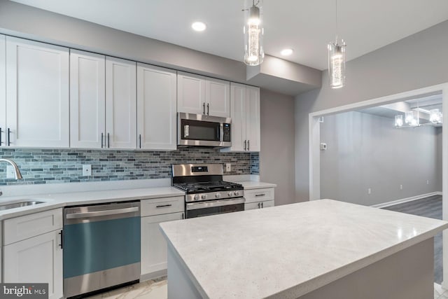 kitchen with a sink, white cabinets, light countertops, appliances with stainless steel finishes, and backsplash