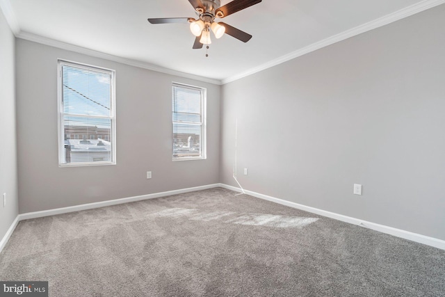 spare room featuring carpet, crown molding, baseboards, and ceiling fan