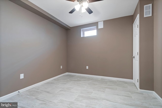 empty room with baseboards, visible vents, and a ceiling fan