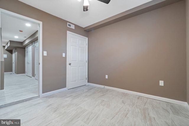 empty room featuring visible vents, ceiling fan, and baseboards