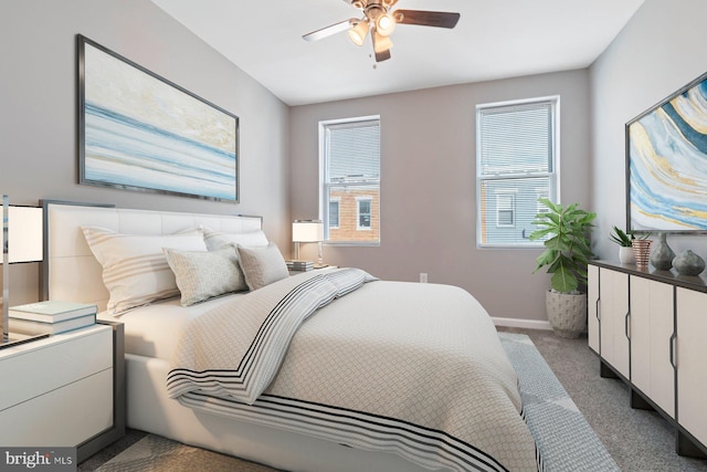 carpeted bedroom featuring ceiling fan and baseboards