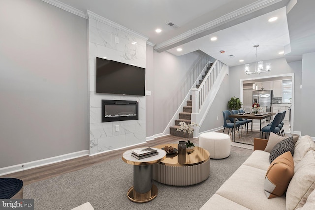 living room with ornamental molding, visible vents, a fireplace, and baseboards