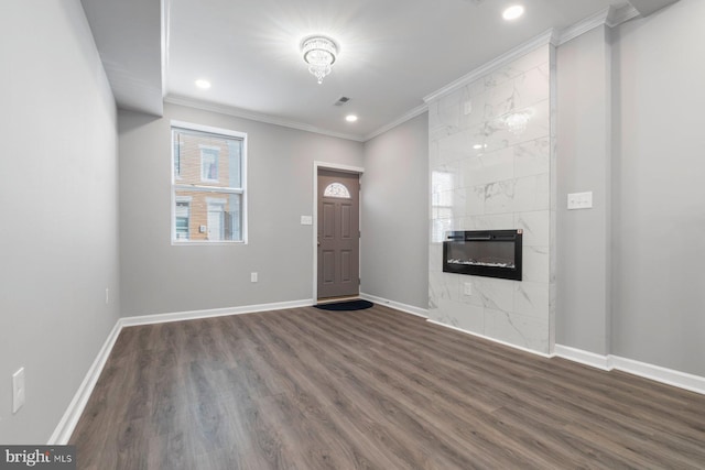 foyer featuring a premium fireplace, baseboards, dark wood-type flooring, and crown molding