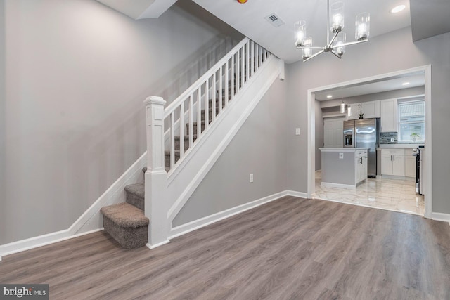 stairs with recessed lighting, visible vents, baseboards, and wood finished floors