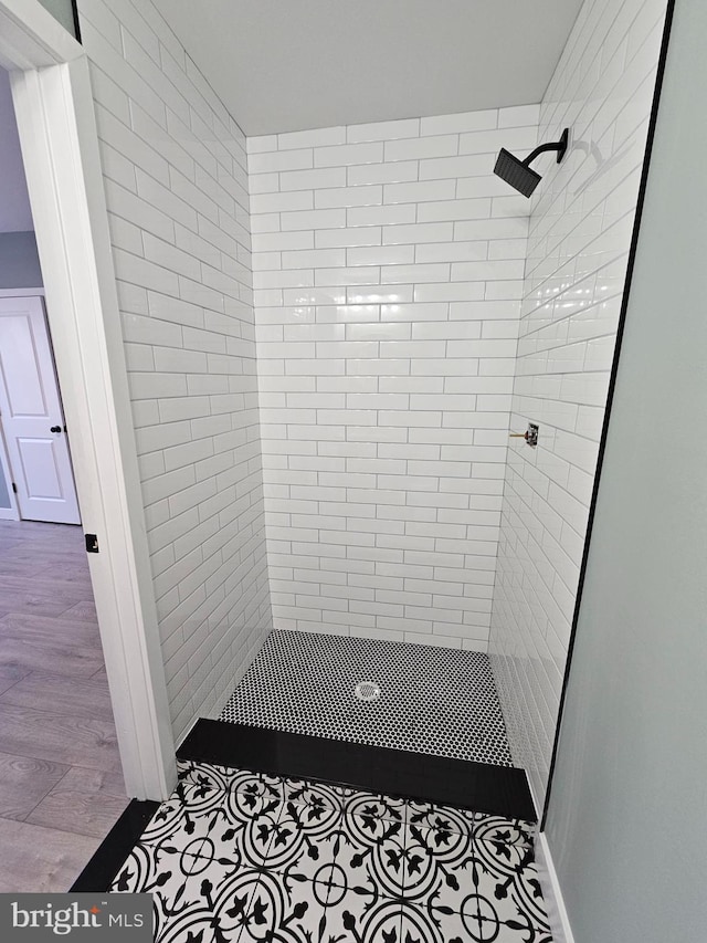 full bath featuring a shower stall and wood finished floors