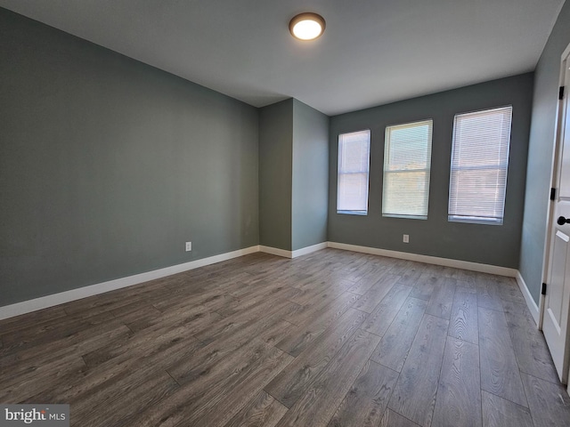 empty room featuring wood finished floors and baseboards