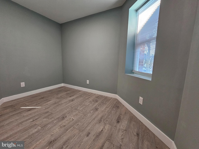 empty room featuring baseboards and wood finished floors