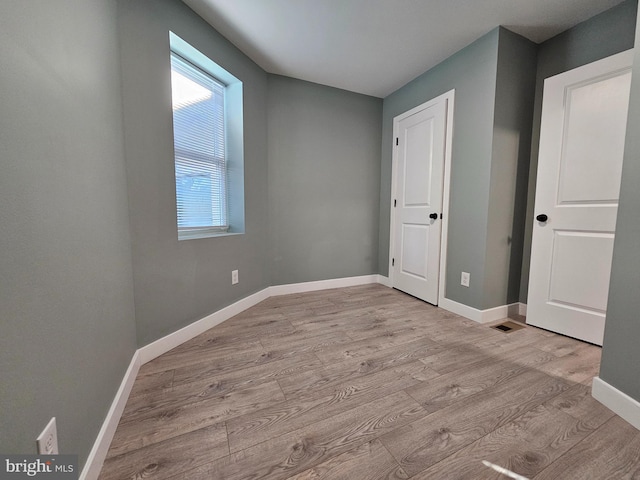 unfurnished bedroom with baseboards and light wood finished floors