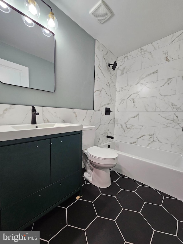 full bath with tile walls, visible vents, toilet, vanity, and shower / tub combination