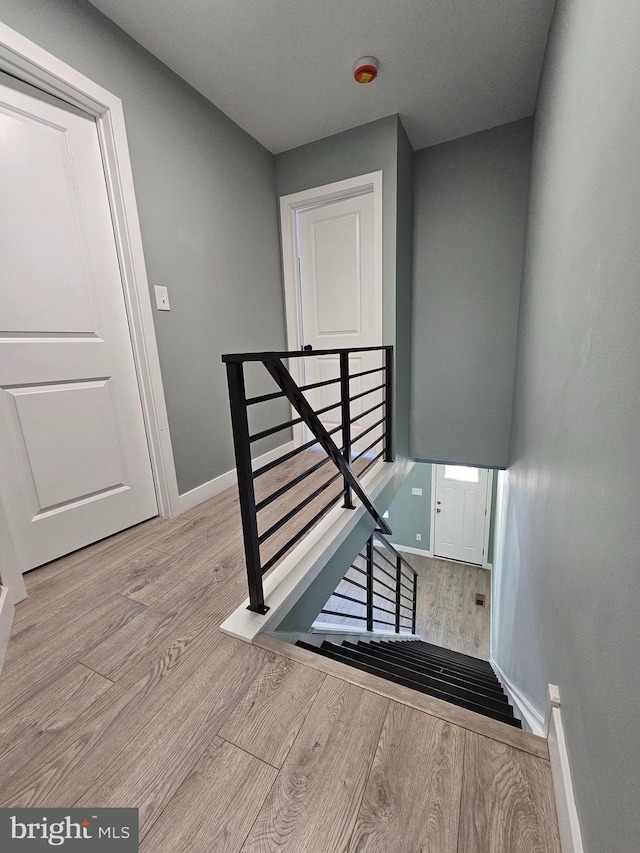 stairway featuring wood finished floors and baseboards