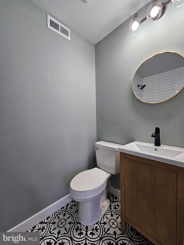 bathroom with toilet, tile patterned floors, visible vents, and baseboards