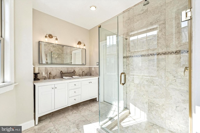 bathroom with a sink, a stall shower, and double vanity