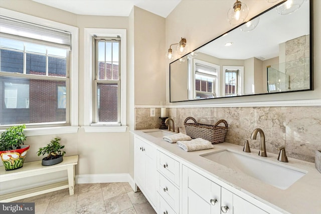 full bathroom with a wealth of natural light, baseboards, and a sink