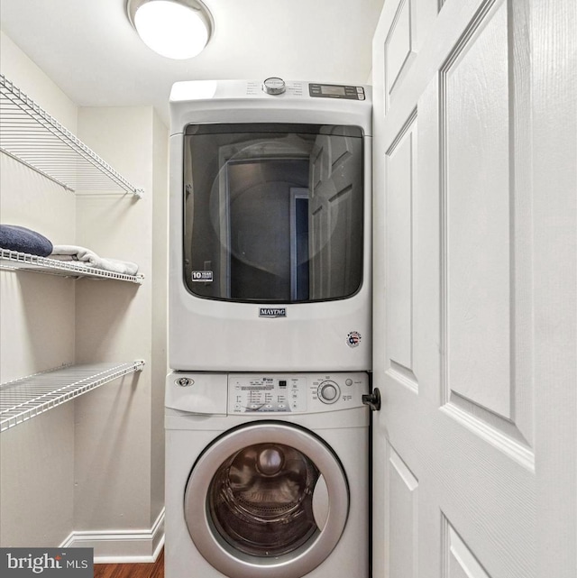 laundry area featuring laundry area, stacked washer and dryer, and baseboards