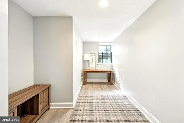 hall featuring baseboards and wood finished floors