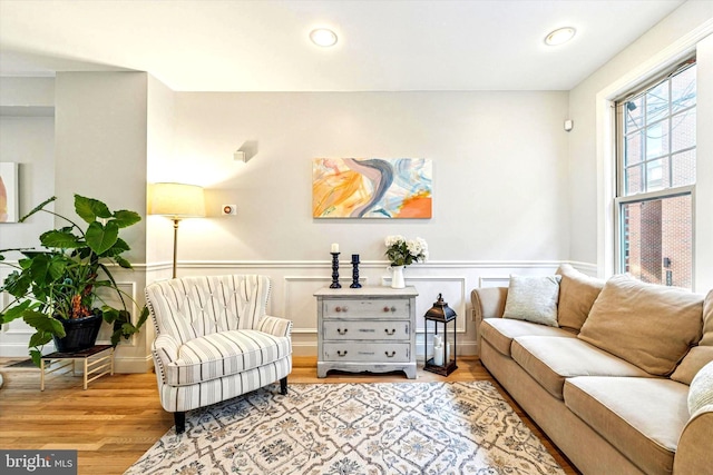 living room featuring recessed lighting, wood finished floors, and a wainscoted wall