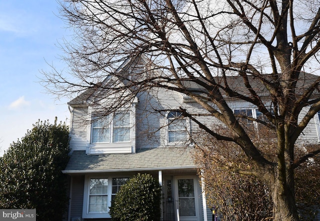 view of side of property with roof with shingles