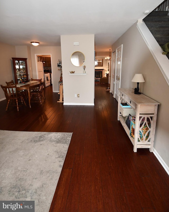 foyer entrance featuring dark wood-style floors, stairway, and baseboards