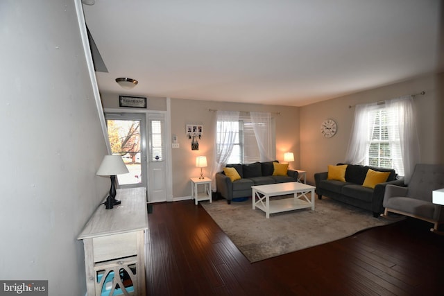 living room with plenty of natural light, baseboards, and dark wood-style flooring