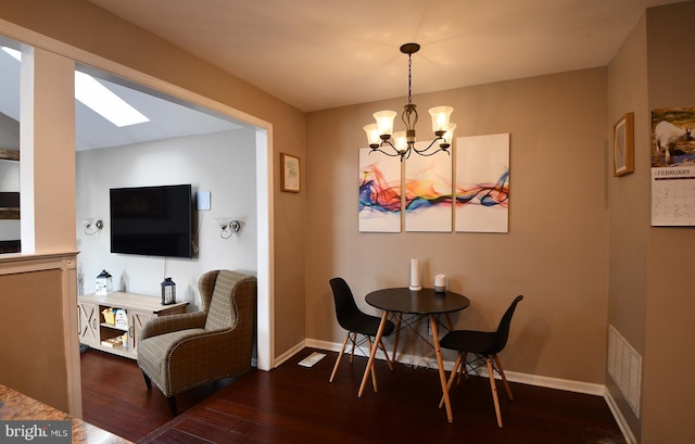 dining room featuring a chandelier, dark wood-type flooring, visible vents, and baseboards