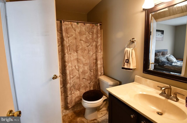 full bath featuring toilet, vanity, and tile patterned floors