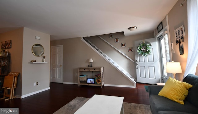 living area with dark wood-style floors, stairs, and baseboards