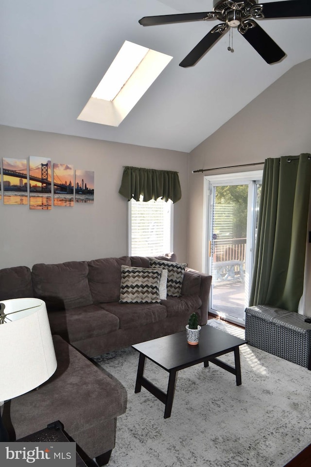 living area with lofted ceiling with skylight and a ceiling fan