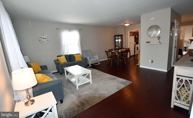 living room with dark wood-type flooring and baseboards