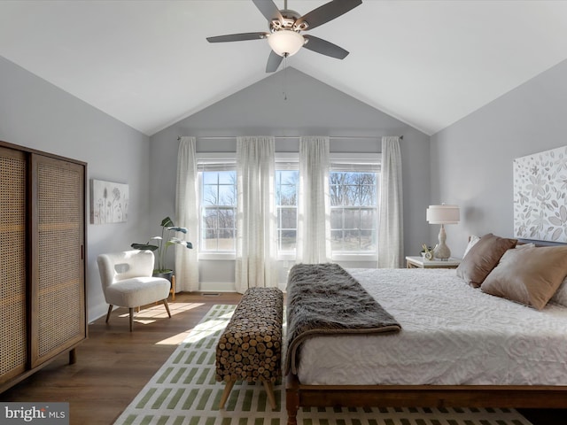 bedroom with ceiling fan, vaulted ceiling, and wood finished floors