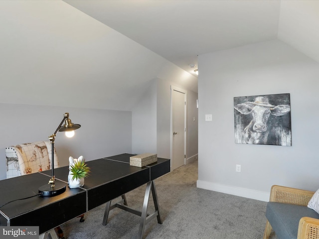 carpeted home office featuring vaulted ceiling and baseboards