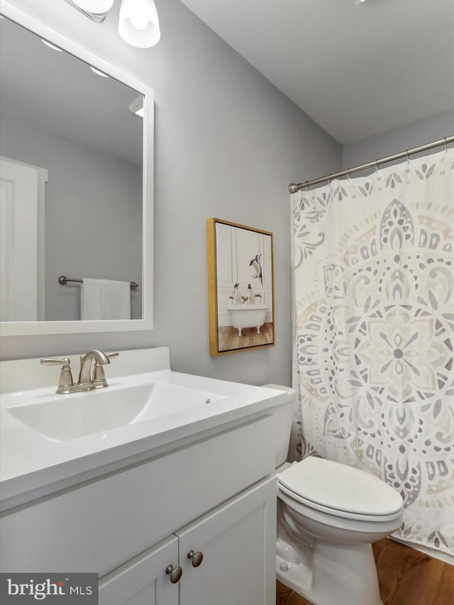 full bathroom featuring toilet, wood finished floors, and vanity