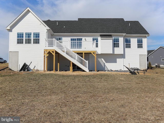 rear view of property with a shingled roof, a yard, a wooden deck, and stairs