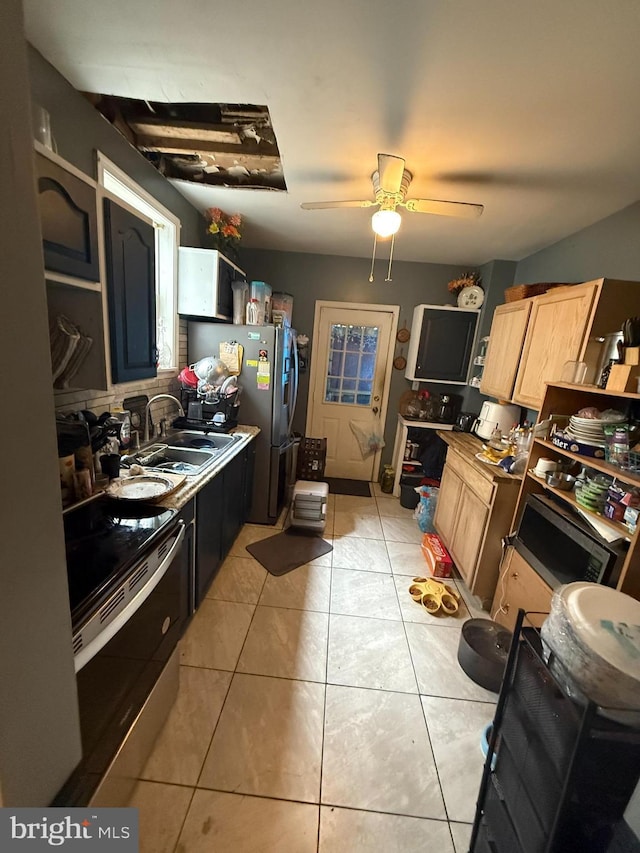 kitchen featuring light tile patterned floors, light brown cabinets, a sink, a ceiling fan, and appliances with stainless steel finishes