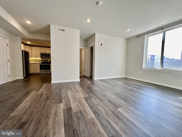 unfurnished living room featuring baseboards, visible vents, dark wood finished floors, and recessed lighting