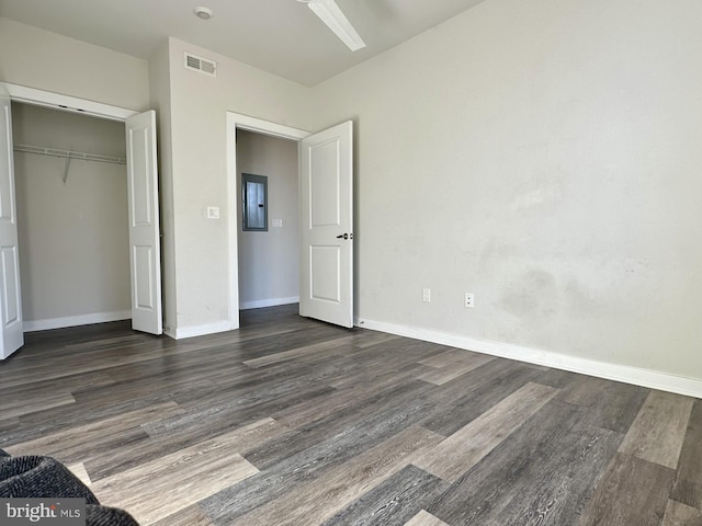 unfurnished bedroom featuring baseboards, a closet, visible vents, and wood finished floors